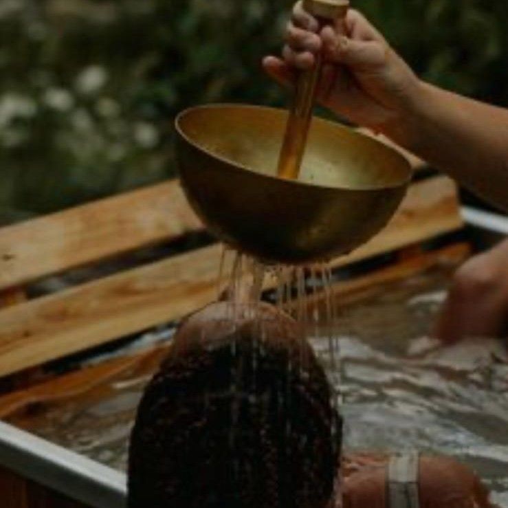 Ritual de lavado de cabello con cuenco de latón vertiendo agua