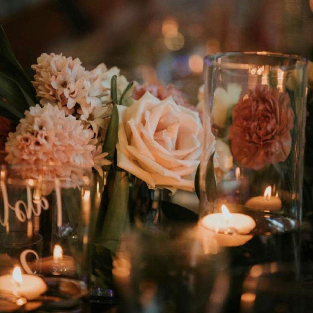 Rosas y peonías junto a velas encendidas