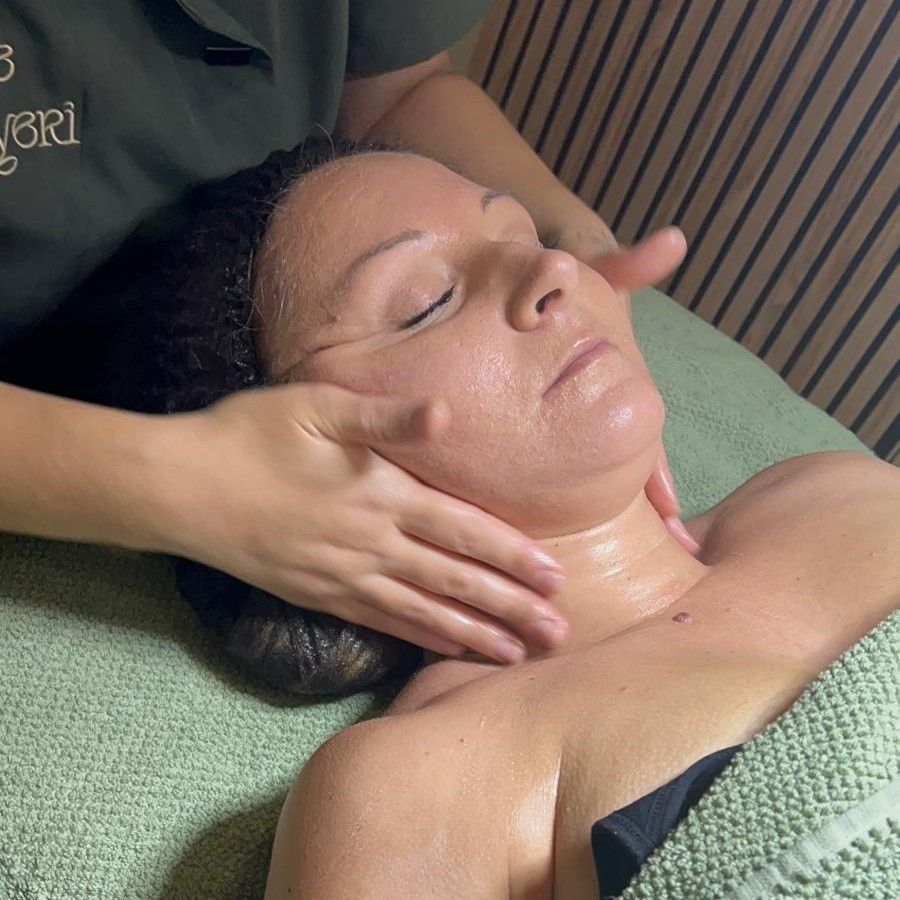 Masaje facial de cerca con la piel húmeda de aceite